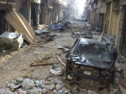 Derrumbres, coches desmantelados, el vestigio de lo que hubo en una calle del centro de Homs queda opacado por los enfrentamientos. ARCHIVO /
