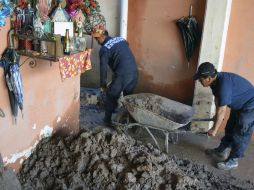 Policías de Guerrero, uno de los estados más afectados, remueven lodo de una vivienda afectada. AP /