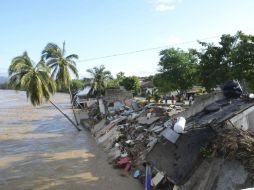Pobladores de Guerrero observan las casas derrumbadas por la fuerza de las inundaciones causadas por ''Manuel''. AP /