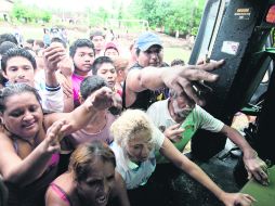 Residentes de San Jerónimo, Guerrero, llegan por víveres a un helicóptero de la Secretaría de Gobernación. AP /