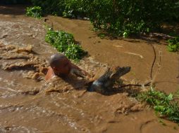 Un hombre rescata a su perro de una inundación provocada por el huracán ''Manuel''. AFP /