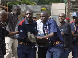 Agentes de seguridad ayudan a una mujer herida en el tiroteo. AFP /