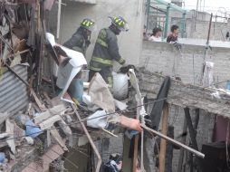 Bomberos ayudan en la remoción de escombros de una casa tras la explosión registrada en Nezahualcóyotl. SUN /