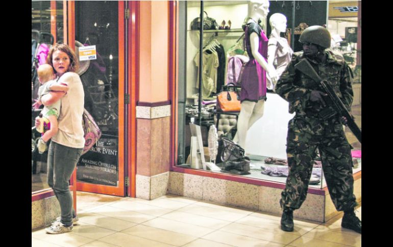 Una mujer protege a su bebé tras el tiroteo en el centro comercial Westgate, mientras un soldado monta guardia en el interior del lugar EFE /