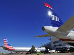Dos aviones de American Airlines (i) y US Airways (d), tras el anuncio de fusión. EFE /