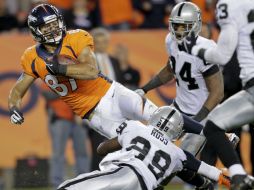 Erin Decker, de los Broncos, es tacleado por el esquinero de los Raiders Brandian Ross. AP /