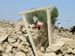 Sobrevivientes del sismo revisan su casa en ruinas. AFP /