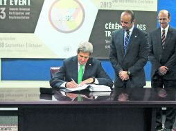 John Kerry (izquierda), firma el tratado que tiene por objeto regular el negocio internacional de armas convencionales. AFP /