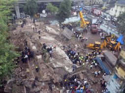 Bomberos y equipos de rescate trabajan en la zona del derrumbe para localizar victimas. AFP /