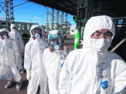 Trabajadores en trajes de protección y con máscaras esperan ingresar a la central nuclear de Fukushima Dai-ichi, en Okuma, Japón. AP /