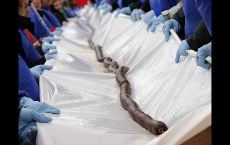 La morcilla se cortó en porciones para venderse entre el público que asistió al acto. AFP /