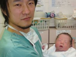 Un doctor sostiene al bebé que nació gracias a la ciencia; otra mujer está aún embarazada. AP /