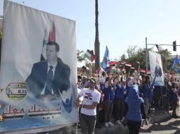 Un grupo de jóvenes exhibe banderas y retratos del presidente, Bachar Al Asad, en apoyo al mandatario sirio. EFE /