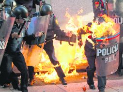 Campo de batalla. La explosión de dos bombas molotov provocó que los uniformes de al menos dos policías se encendieran. AP /