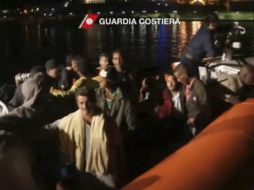 Miembros del equipo de rescatistas llevan a los sobrevivientes a la costa en una lancha. AP /