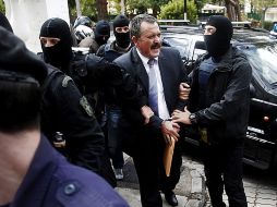 Policías escoltan a Christos Pappas (c), miembro de Amanecer Dorado, a su llegada a los tribunales en Atenas. EFE /