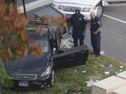 Policías observan el automóvil donde viajaba la mujer que presuntamente provocó el incidente. EFE /