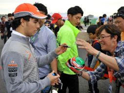 'Checo' ofrece algunos autógrafos a sus admiradores dentro del circuito de Corea. AFP /