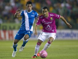 Gustavo Alustiza (i) disputa el balón con el jugador del León Edwin Hernández (d). AFP /