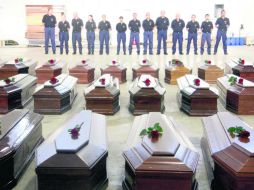 Agentes custodian los féretros de las víctimas en un hangar  del aeropuerto de Lampedusa. EFE /