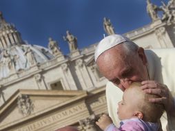 Francisco besa a un bebé antes de presidir la audiencia general de los miércoles en la plaza de San Pedro. EFE /