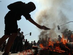 Un estudiante quema cuadernos durante la manifestación. EFE /
