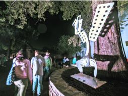 Los asistentes al festival pasan frente a la escultura ''Ángel Blanco'', una pieza que se suma al Jardín Escultórico de Tapalpa.  /