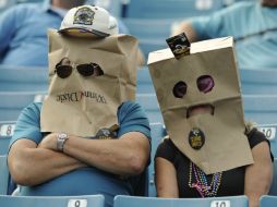 Los aficionados de los Jaguares esconden sus rostros ante la pobre marcha del equipo. AP /
