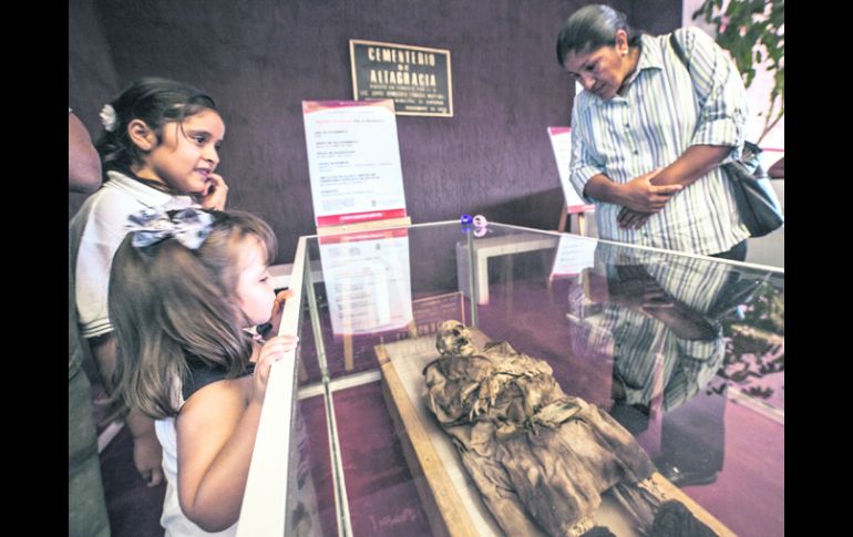 Cementerio de Altagracia. Visitantes observan uno de los cinco cuerpos momificados que fueron puestos en exhibición.  /