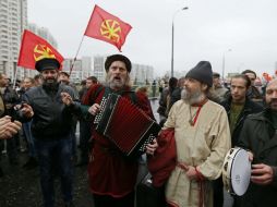 Nacionalistas rusos vestidos con trajes populares cantan durante la marcha. EFE /