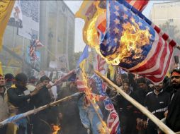 Un grupo de manifestantes quema banderas y efigies estadounidenses durante el 34 aniversario del fin de las relaciones con EU. NTX /