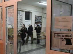 Miembros de una comisión electoral dejan un centro de votación en Mitrovica después de que unos desconocidos atacaron el sitio. EFE /