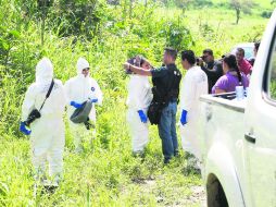 Peritos forenses y agentes ministeriales en la zona donde llevarán a cabo el levantamiento de un cuerpo.  /