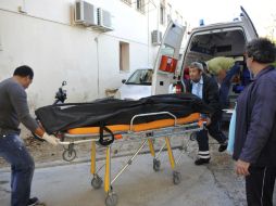 Personal médico trasladan el cadáver de un inmigrante hasta la morgue del hospital local de la isla jónica de Lefkada. ARCHIVO /