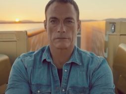 La estrella del cine de los años noventa aparece montado sobre los espejos laterales de dos camiones en movimiento. ESPECIAL /