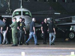 José Dirceu (tercero a la derecha), implicado en el escándado ''mensalão'', a su llegada al hangar de la Policía Federal en Brasilia. AFP /