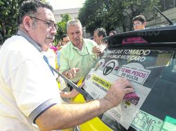 Conductores recibieron los engomados que los acreditan como parte del programa. De momento son más de 200 los taxis que participarán.  /