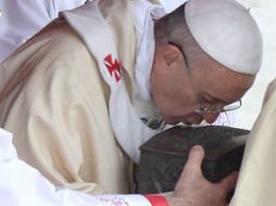 El Papa Francisco besa los restos de San Pedro durante la celebración de la Santa Misa. AP /