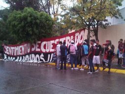 Aficionados rojinegros protestan afuera de la asamblea del Atlas.  /