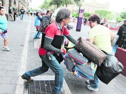 Un inspector del Ayuntamiento tapatío arrebata su mercancía a una vendedora ambulante, quien ofertaba bolsas en el Centro Histórico.  /