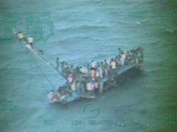 En las fotografías difundidas, se puede ver a los migrantes sobrevivientes tratando de salir de la embarcación. AFP /