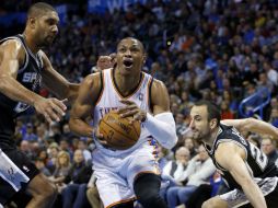 Russell Westbrook del Oklahoma City (0) impulsa entre San Antonio Spurs Tim Duncan (21) y el guardia Manu Ginóbili (20). AP /