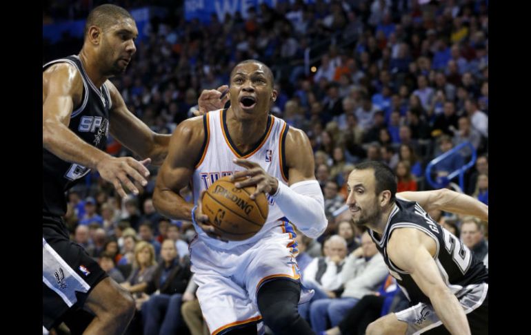 Russell Westbrook del Oklahoma City (0) impulsa entre San Antonio Spurs Tim Duncan (21) y el guardia Manu Ginóbili (20). AP /