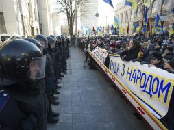'El Parlamento ucraniano está con el pueblo' silgla una pancarta delante de un fuerte cordón policial durante una protesta. EFE /