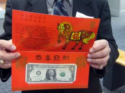 Cheng Wang, jubilado de la Oficina de Grabado e Impresión, presenta uno de los billetes especiales. AFP /