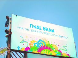 Trabajadores colocan los últimos anuncios del evento en Costa do Sauipe, con el que empezará a sentirse en realidad la Copa del Mundo. AFP /