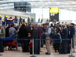 Pasajeros hacen fila para volver a reservar vuelos en el Heathrow Airport de Londres. AP /