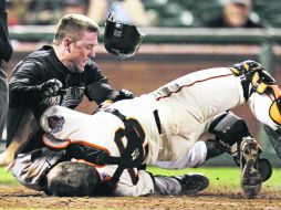 Ouch. Scott Cousins arrolla en el plato a Buster Posey. El receptor de San Francisco terminó con fractura en el pie izquierdo. AP /