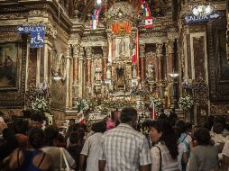 Le cantan, llevan flores o sólo asisten a mirarla en el altar.  /