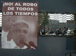 Integrantes de Morena despliegan pancartas para manifestarse en contra de la reforma energética. AFP /